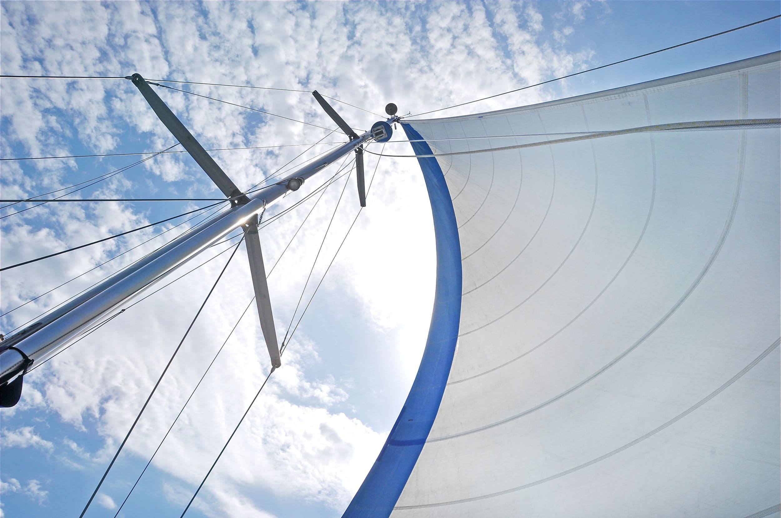 Looking up high at a boat mast with sky background