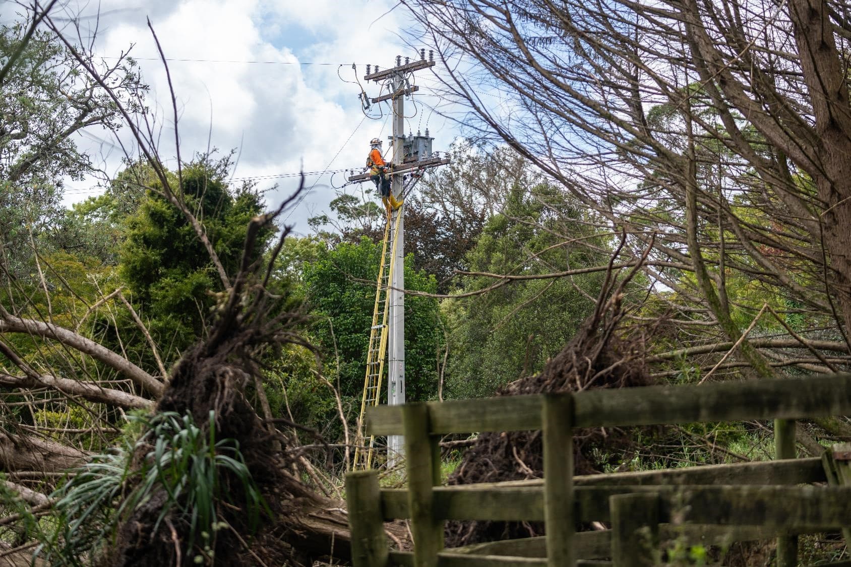 Crews on ladder fixing power lines