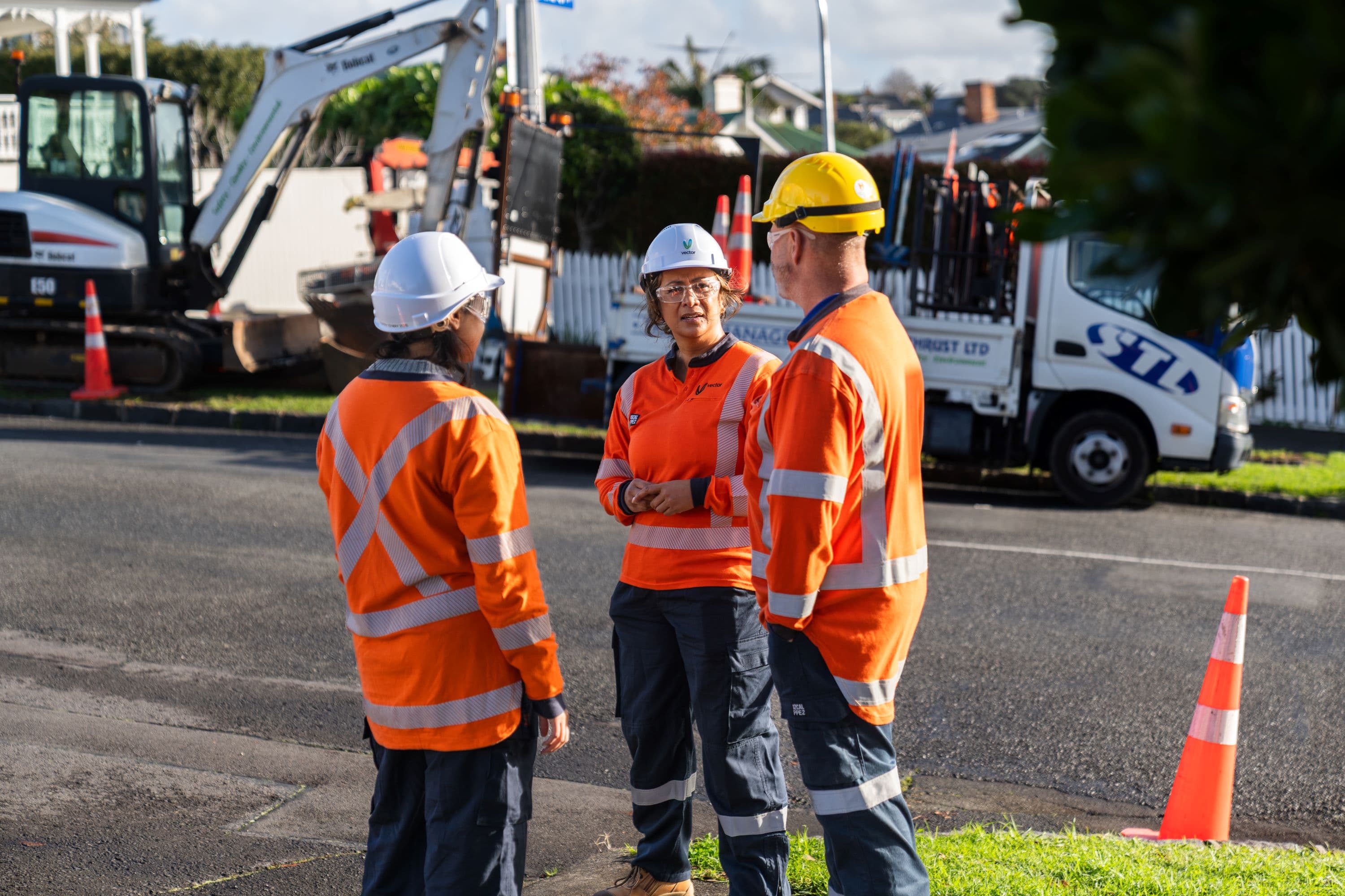 Three contractors talking on residential street about working taking place