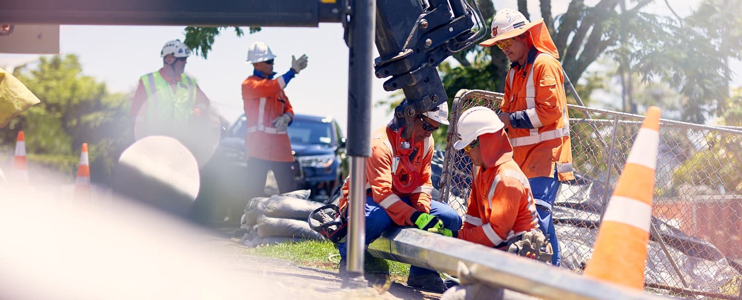 five work crew working on a fallen powerpole at side of road