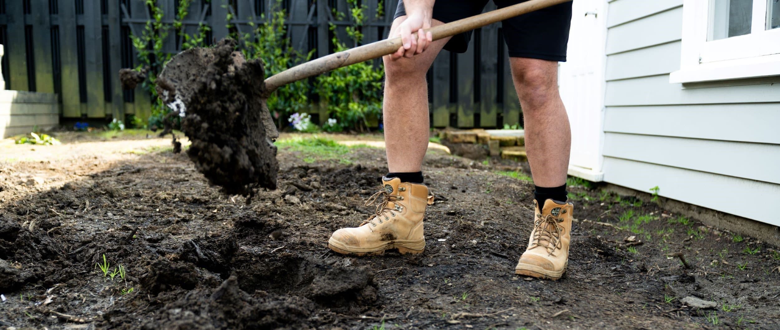 legs and boots of person who is digging in garden